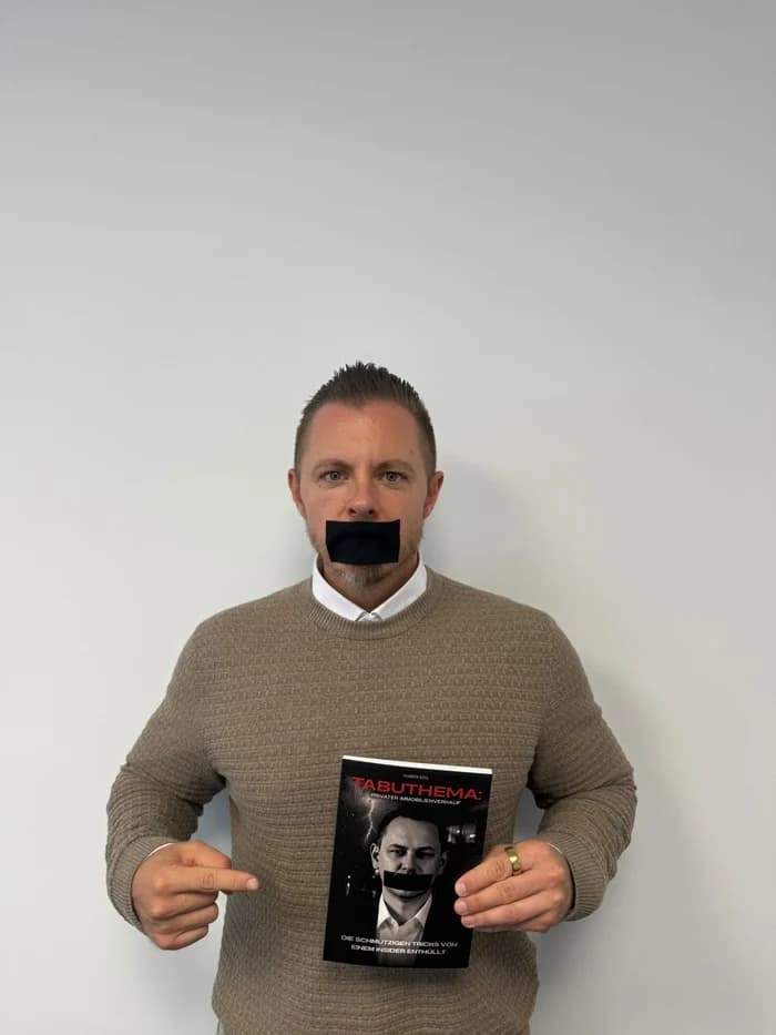 Partner von Markus Kehl im Pullover mit dem Buch